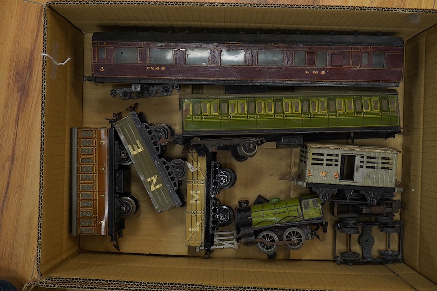 A collection of mainly Hornby 0 gauge tinplate model railway, including; an M series 0-4-0 clockwork locomotive, a bogie coach, 4-wheel coach, seven freight wagons, two boxed buffer stops, and two boxes of 3-rail track s